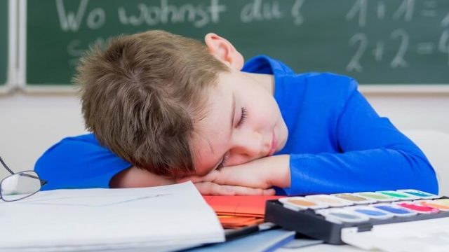 机に伏せる子供